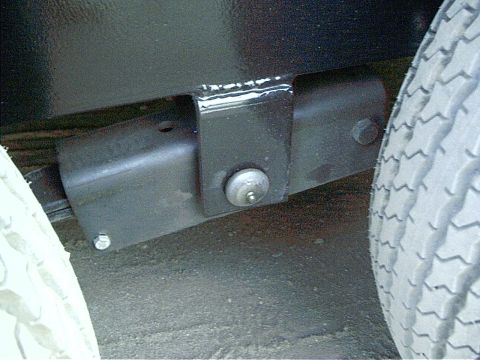 1979 Ford Bronco - Close-up view of a trailer's suspension system, showing a bracket and a tire.
