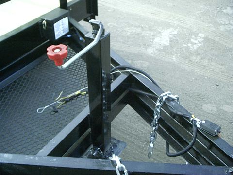 1979 Ford Bronco - Close-up view of a trailer's tongue mechanism, including a winch and safety chains.