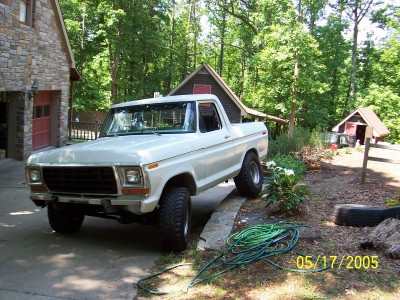 1979 Ford Bronco - 1979 Ford Bronco parked in a driveway with a house and trees visible.
