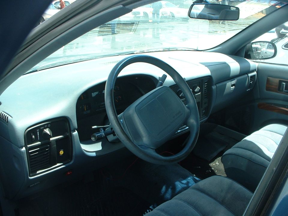 Car interior showing dashboard, steering wheel, and front seats. A watermark reads SUPERMOTORS