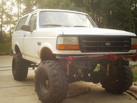 1996 Ford Bronco - This modified Ford Bronco features large off-road tires and a Hi-Lift jack mounted to its front bumper.
