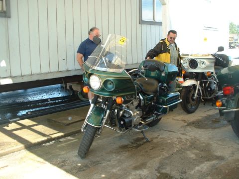 1999 Ford Crown Victoria - Several motorcycles are parked outside a building. One green motorcycle is in the foreground.