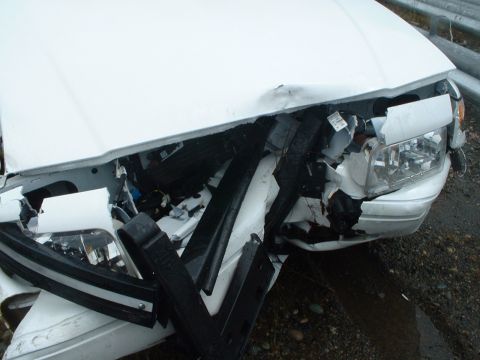 1999 Ford Crown Victoria - The front of a white 1999 Ford Crown Victoria shows significant damage from an apparent collision.