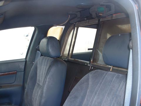 1999 Ford Crown Victoria - Interior view of a 1999 Ford Crown Victoria, likely a former police vehicle, with partition.