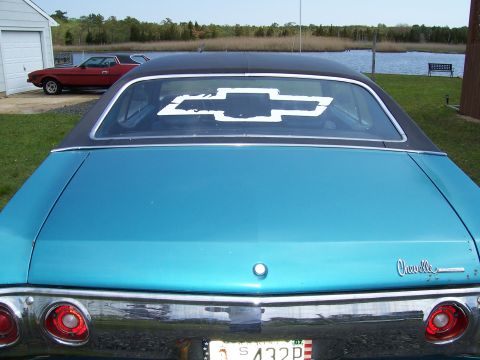 1971 Chevrolet Chevelle - Rear view of a blue 1971 Chevrolet Chevelle with a black roof and a large bowtie decal on the window.
