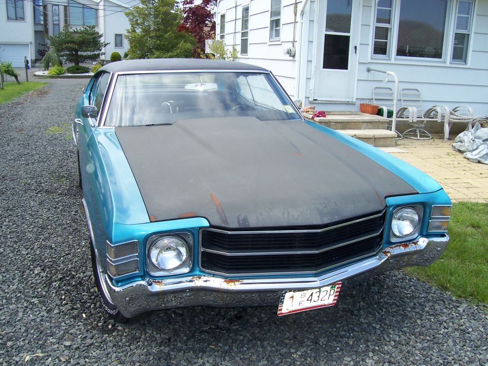1971 Chevrolet Chevelle front view, blue body with matte black hood, parked on gravel driveway