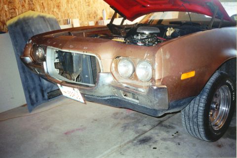 1972 Ford Ranchero - The front of a 1972 Ford Ranchero is shown with the hood up, revealing the engine bay and some of the interior.