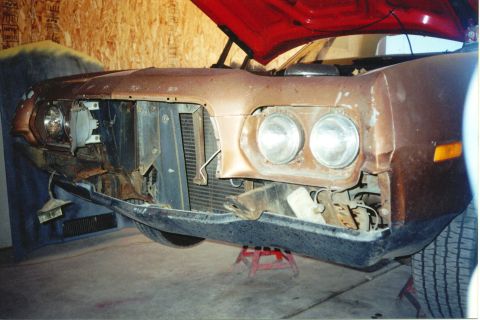1972 Ford Ranchero - The front end of a 1972 Ford Ranchero shows significant damage, with the hood propped open and the grille missing.