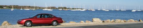 1998 Ford Taurus - Red 1998 Ford Taurus parked by the water with many sailboats on a clear day.