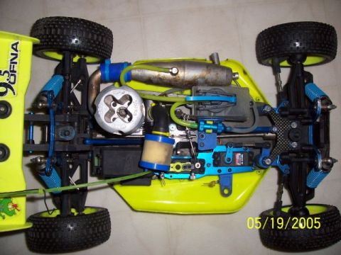 1987 Ford Bronco - Underside view of a remote control car chassis, showing its intricate mechanical components and bright yellow body.