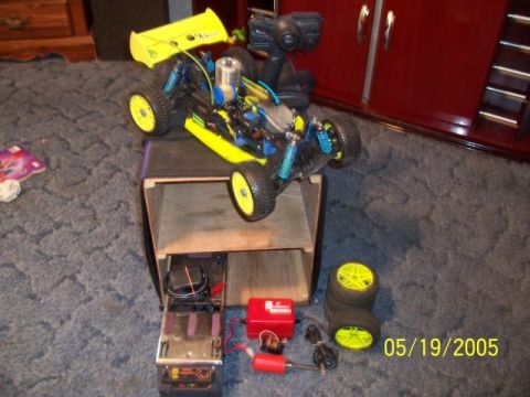 1987 Ford Bronco - A remote control nitro buggy is displayed with its accessories, including extra wheels and a controller.