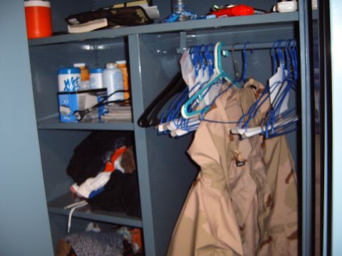 1988 Ford Bronco - Interior view of a shelving unit containing clothing, bottles, and various supplies.