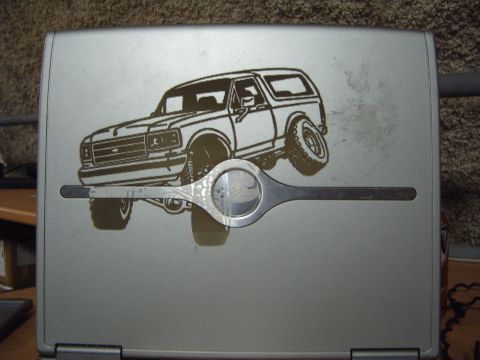1988 Ford Bronco - Laptop lid features a decal of a Ford Bronco, overlaid by a metal tool.