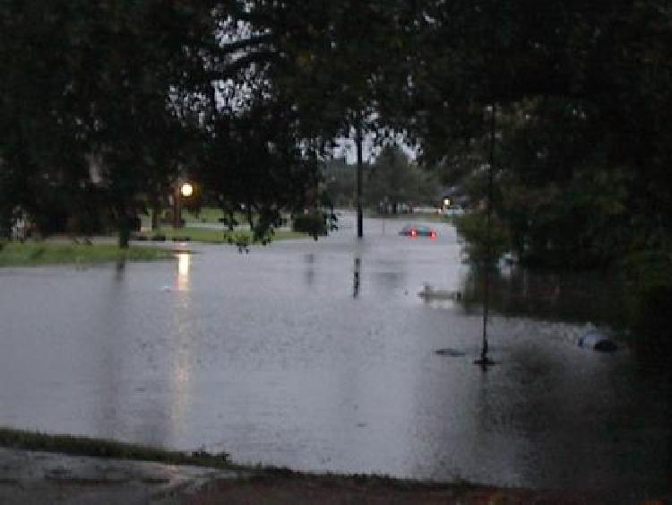 Flooded street at dusk with partially submerged cars