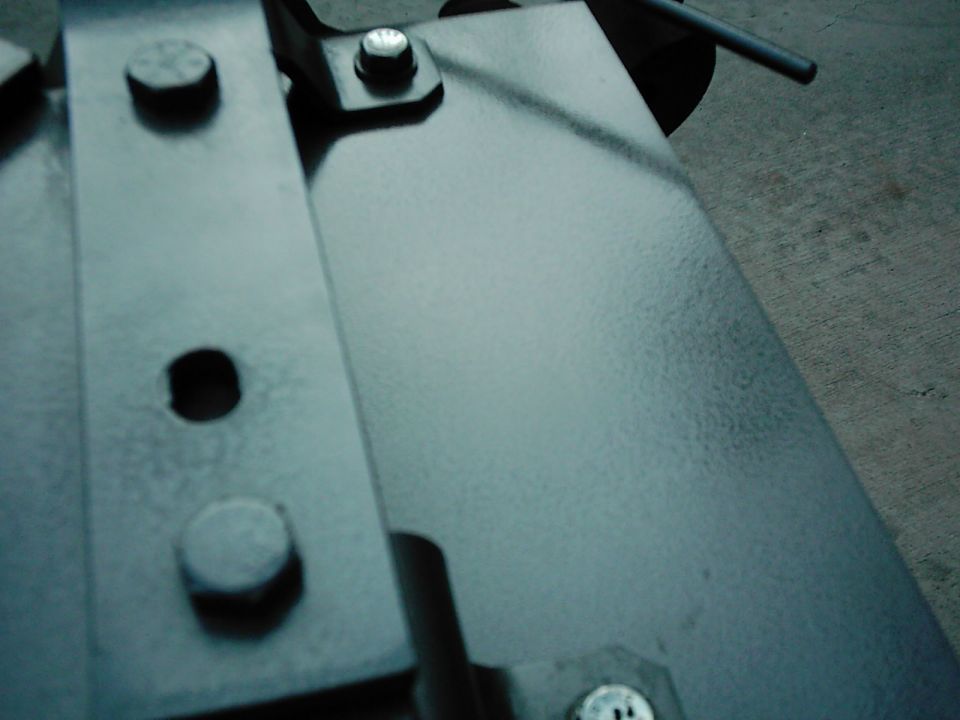 Close-up of metal brackets and bolts, with a SUPERMOTORS watermark at the bottom right
