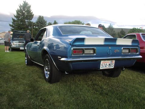 1979 Ford Bronco - Blue 1968 Chevrolet Camaro parked on grass at an outdoor car show. Another vehicle is visible to the right.