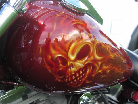 1979 Ford Bronco - A detailed airbrush design of a skull engulfed in flames adorns a motorcycle's fuel tank.