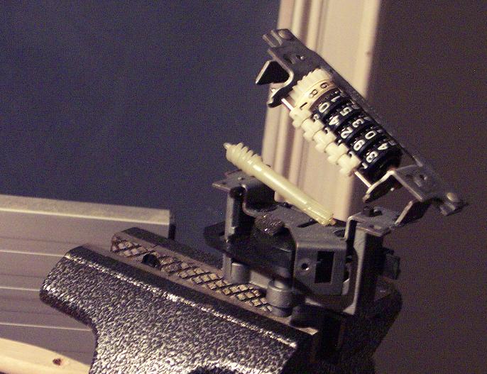 Odometer roller mechanism held in a vise, showing numbered wheels