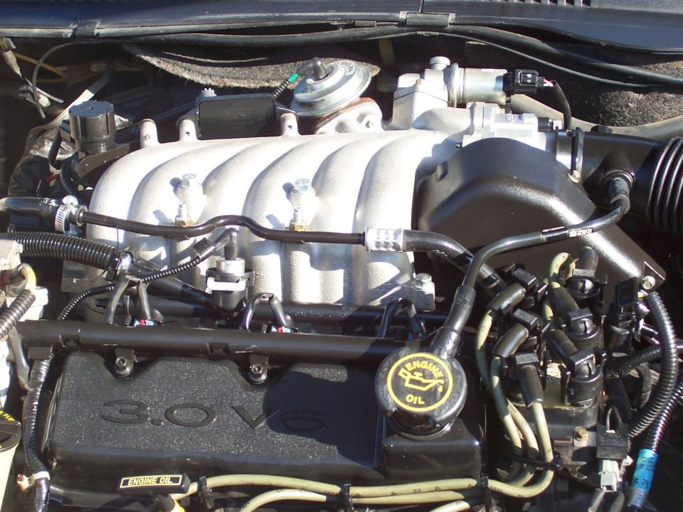 Close-up of a Ford 3.0L V6 engine, showing the intake manifold, spark plug wires, and oil cap
