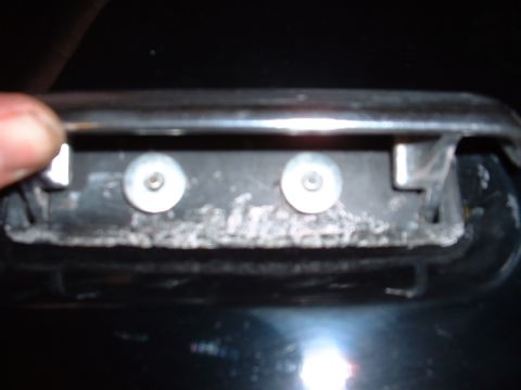 1978 Ford Mustang II - Mounting bracket for a car door handle, showing two screws and signs of wear.