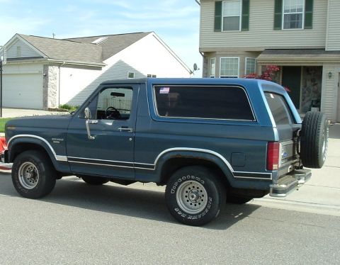 1982 Ford Bronco - This blue SUV appears to be from the early 1980s, with a spare tire mounted on the back.