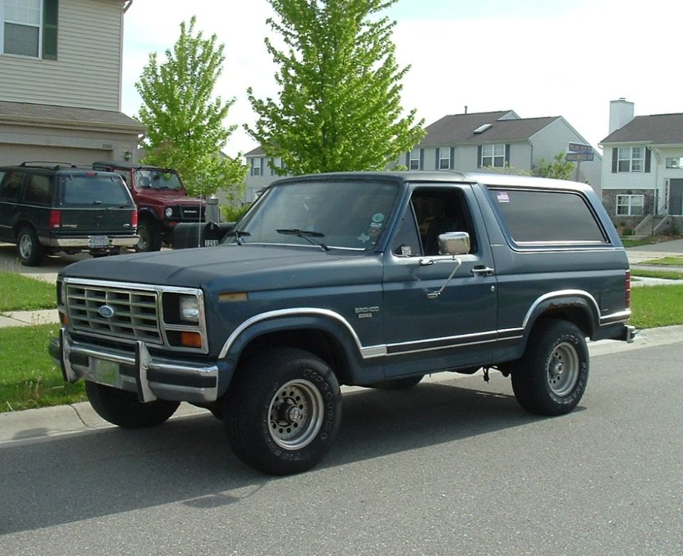 Dark blue 1982 Ford Bronco parked curbside, three-quarter front view