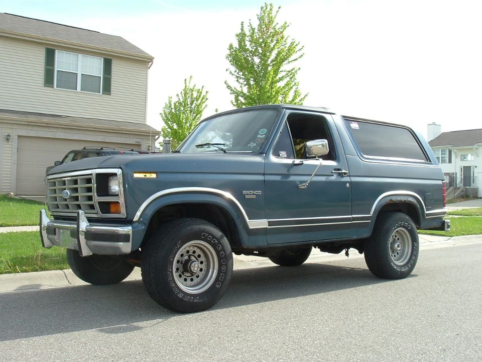 Blue Ford Bronco parked on street in front of house