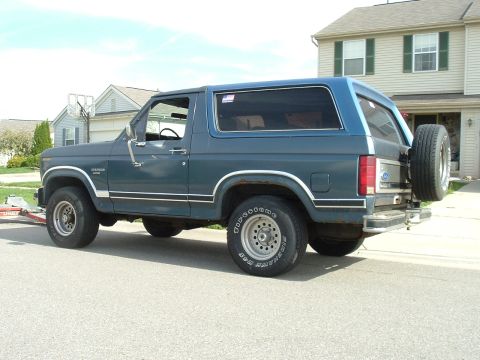 1982 Ford Bronco - This blue Ford Bronco, likely from the early 1980s, is parked on a residential street.