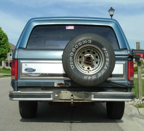 1982 Ford Bronco - The rear of a blue 1982 Ford Bronco is shown, a spare tire mounted on the tailgate.