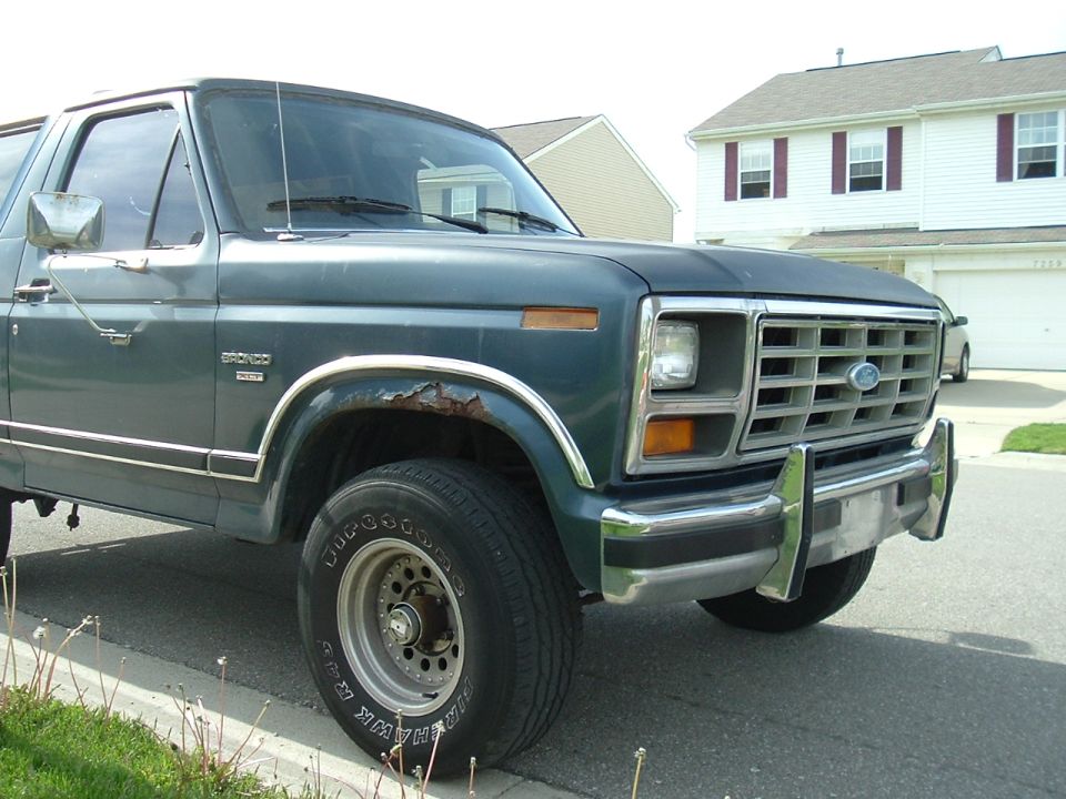 Green Ford Bronco, front quarter view. Shows rust on fender