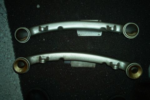 1992 Ford Taurus - Two silver control arms are shown, likely for a vehicle's suspension system.