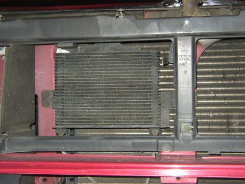 1995 Ford Bronco - The front of a vehicle shows its radiator and transmission cooler, with red body panels visible.
