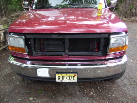 1995 Ford Bronco - Front view of a red 1995 Ford Bronco with its grille removed, revealing the radiator.