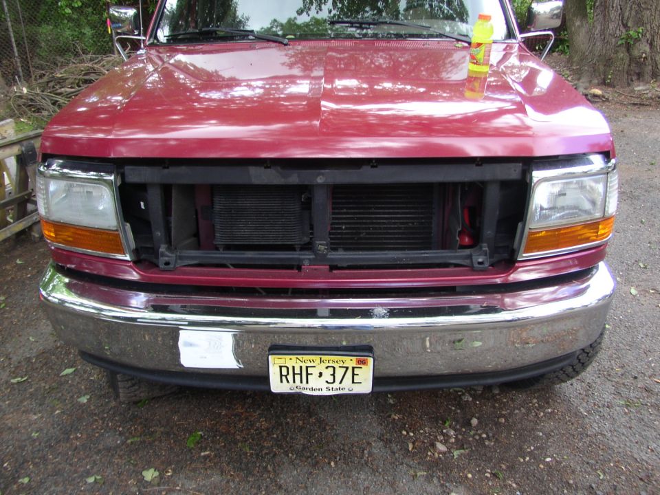 Red truck front end, missing grille, 1995 Ford Bronco