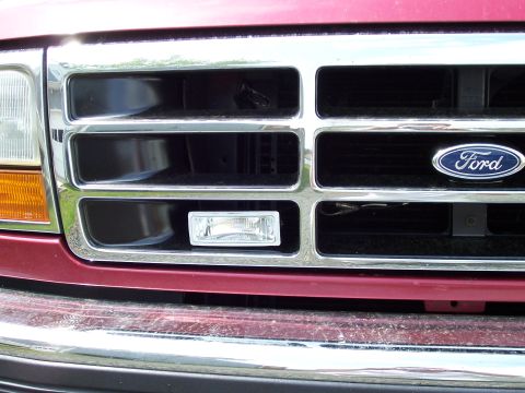 1995 Ford Bronco - The front grille of a 1995 Ford Bronco features chrome accents and the iconic Ford emblem.