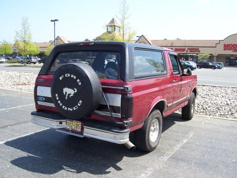 1995 Ford Bronco - The rear view of a red Ford Bronco shows its spare tire and license plate.