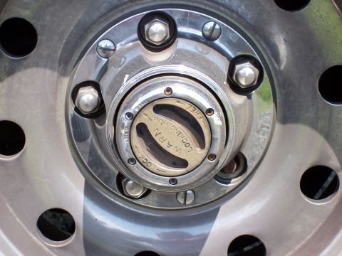 1995 Ford Bronco - Close-up of a WARN locking hub on a vehicle's wheel.
