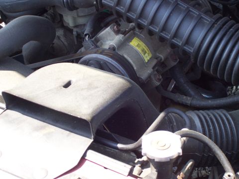 1995 Ford Bronco - The engine bay shows various parts like the air intake and a compressor unit.