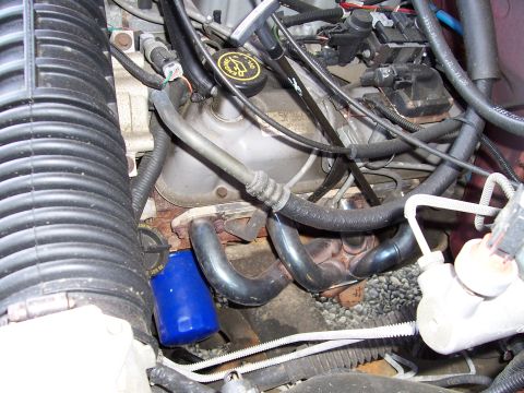 1995 Ford Bronco - Close-up view of an engine bay, highlighting a blue oil filter and exhaust components.