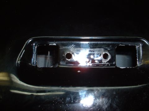 1978 Ford Mustang II - Close-up view of a chrome bumper section, showing two circular holes and rectangular cutouts.
