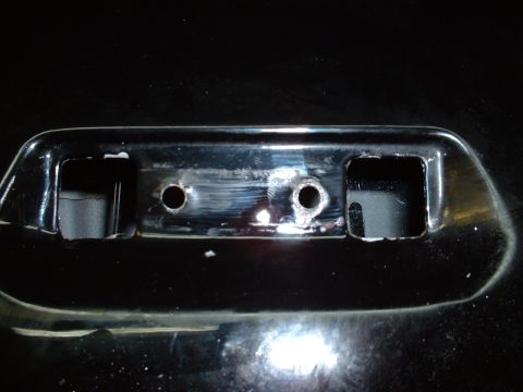 1978 Ford Mustang II - Close-up of a chrome bumperette showing mounting holes and an opening.