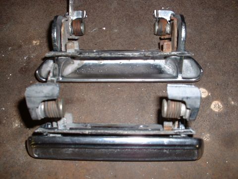 1978 Ford Mustang II - Two chrome car door handles are shown, detached from a vehicle, with visible internal mechanisms and mounting components.