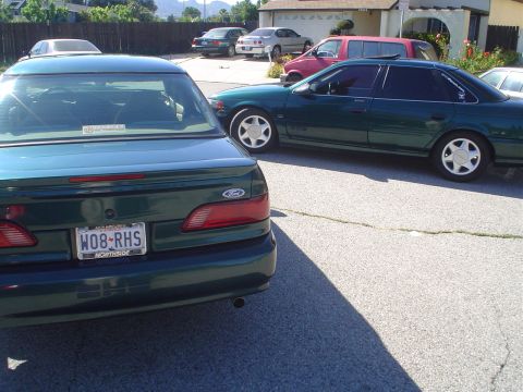 1995 Ford Taurus - A 1995 Ford Taurus is seen from the rear, parked next to another sedan.