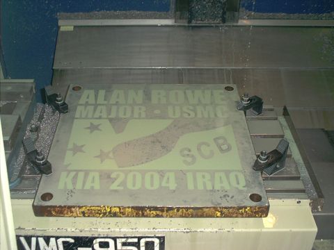 1966 Ford Bronco - A machined steel memorial plaque clamped in a VMC-950 CNC mill, engraved 'ALAN ROWE MAJOR · USMC' above a bronco horse silhouette with thre…
