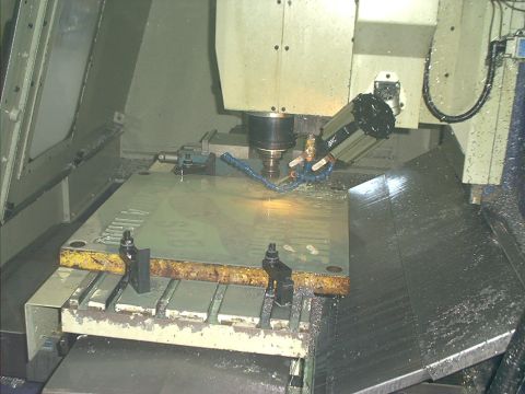 1966 Ford Bronco - A CNC milling machine is actively cutting a large metal plate, with coolant spraying onto the workpiece.