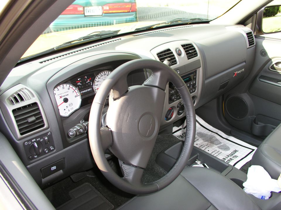 Gray Chevrolet Colorado Xtreme interior with white-face gauges seen from the driver's door