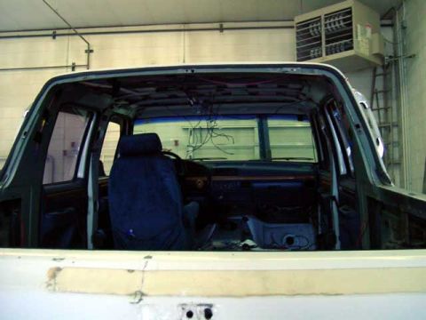 1994 Ford C-350 (Centurion Conversions) - The interior of a truck is visible, showing exposed wiring and a blue seat cover.
