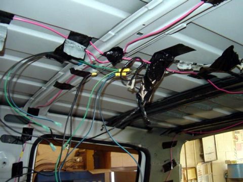 1994 Ford C-350 (Centurion Conversions) - The interior ceiling of a vehicle shows a complex network of wires and electrical connections.