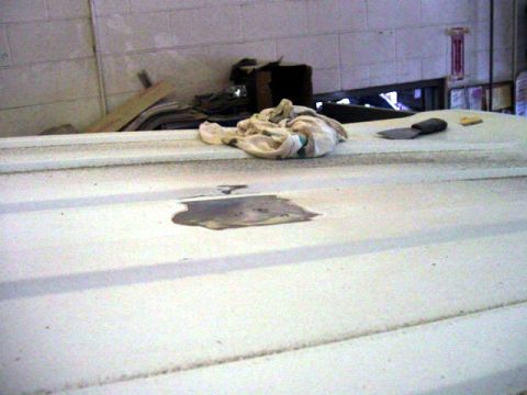 1994 Ford C-350 (Centurion Conversions) - A close-up view of a damaged white vehicle roof, showing rust and a discarded rag.