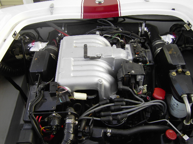 Marine inboard engine with silver intake manifold in white boat engine bay